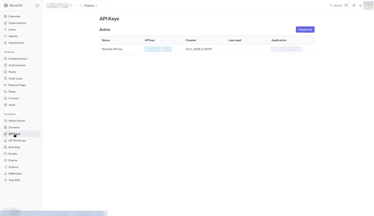 The WorkOS API Keys page with a Create key button and an Active table holding one key named WorkOS API key. The masked key and the application name are blurred.
