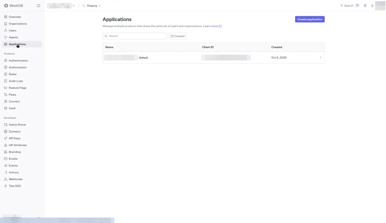 The WorkOS Applications page with a Search box, a Created filter, and a table with Name, Client ID, and Created columns. One application is marked Default. Its name and Client ID are blurred.